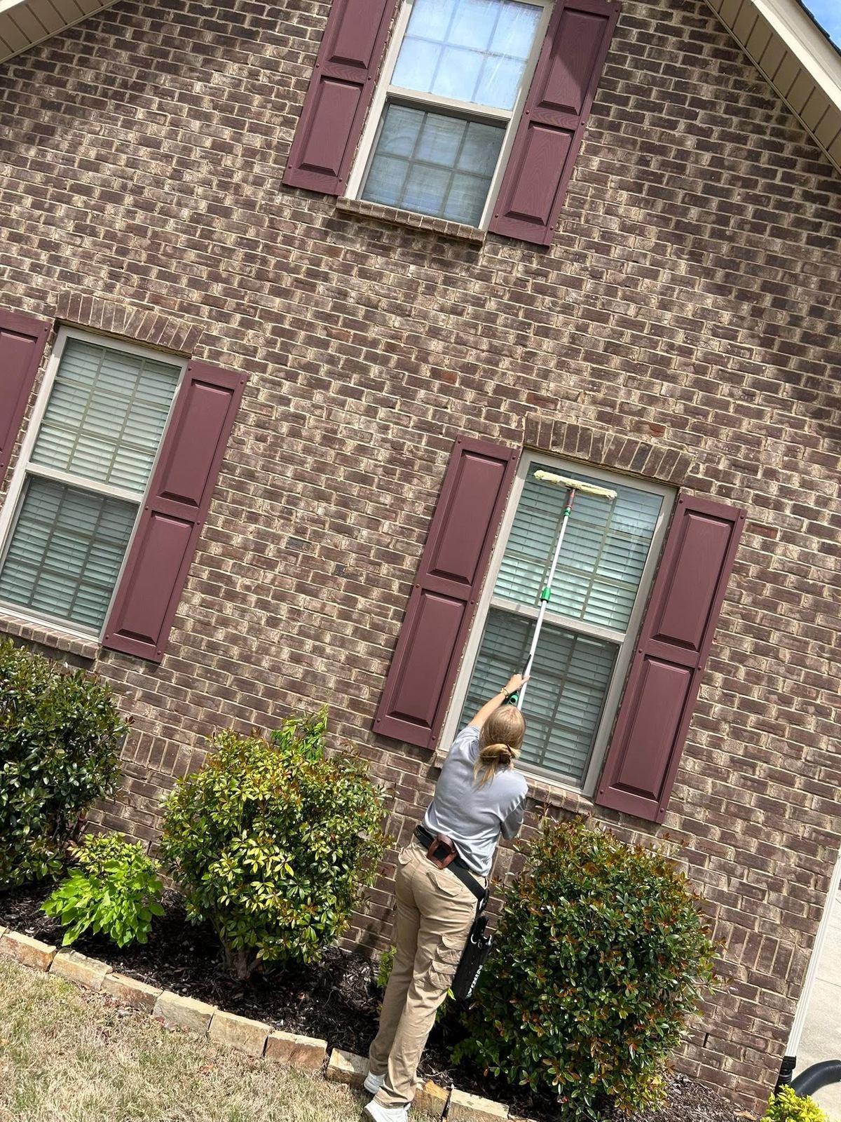 Tucker's Window Cleaning technician using a pole squeegee for a streak-free finish