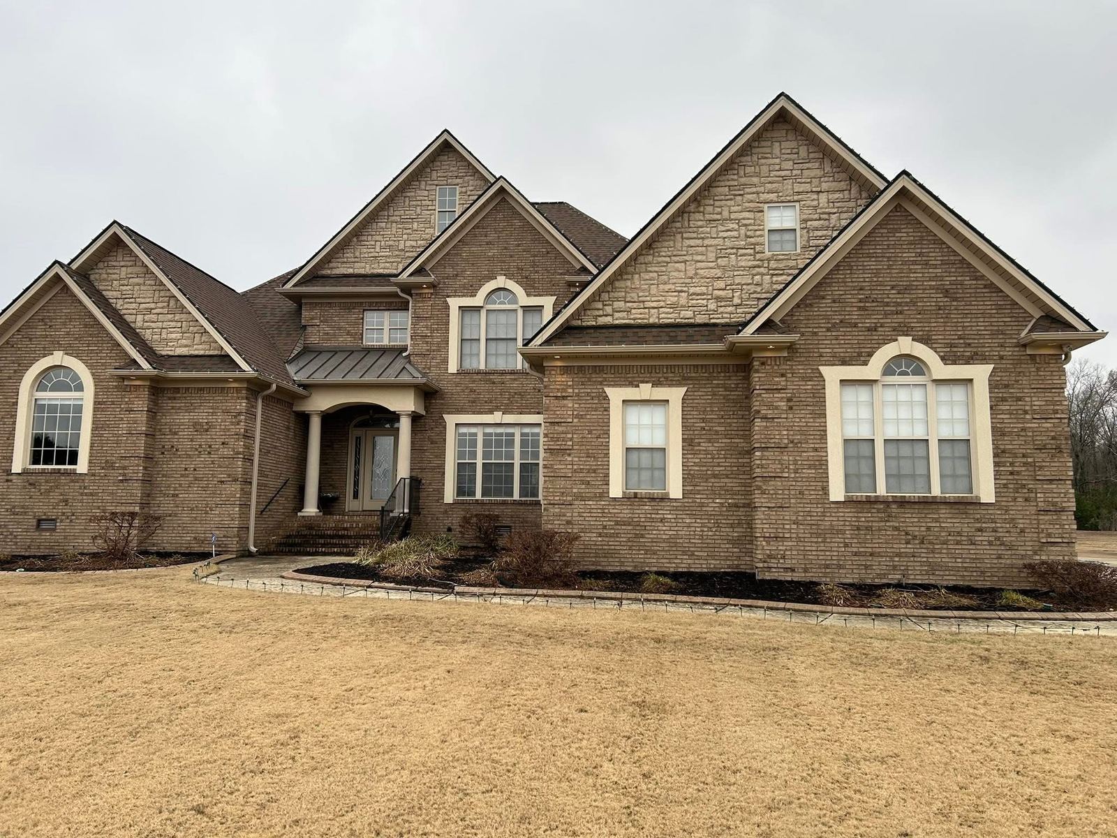 Large stone and brick home exterior with sparkling windows
